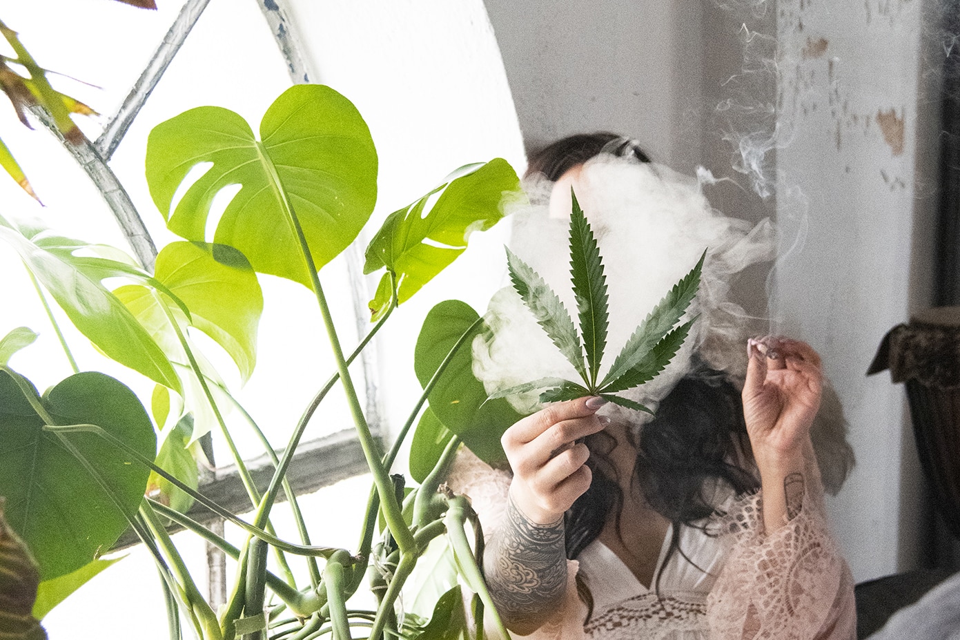 woman smoking holding cannabis leaf