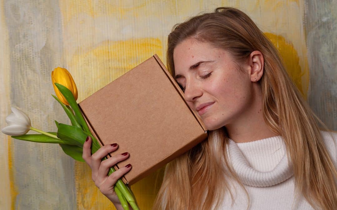 woman holding flowers and box